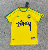 A short-sleeved soccer jersey in yellow with green accents, featuring the Nike logo and the name &